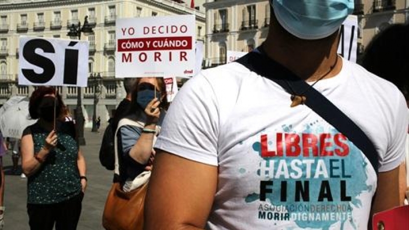 Un grupo de personas se reúne sosteniendo pancartas y carteles durante la concentración de la asociación Derecho a Morir Dignamente (DMD) en la Puerta del Sol, a 25 de junio de 2021, en Madrid, (España).