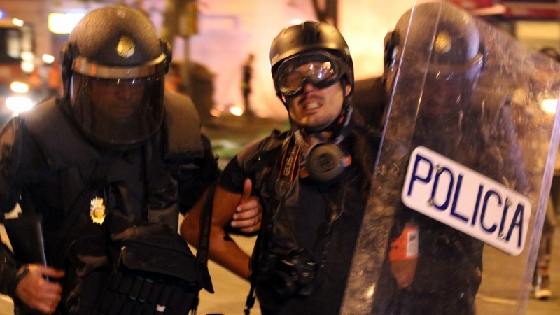 El moment en què la Policia Nacional s'endú detingut i emmanillat per l'esquena el fotoperiodista d'El País Albert Garcia a la plaça Urquinaona de Barcelona el 18 d'octubre del 2019.