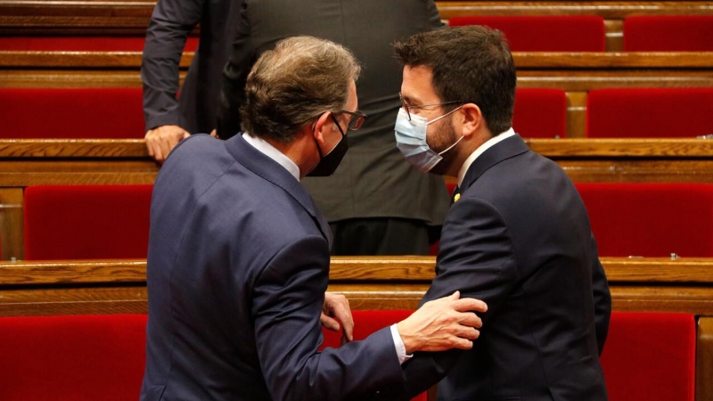 El conseller d'Economia i Hisenda, Jaume Giró, parla amb el president Aragonès al Parlament durant un ple .