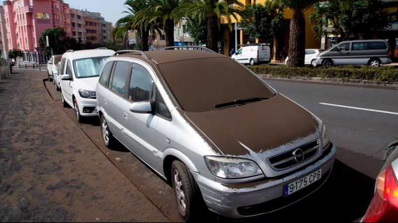 Imagen de este lunes de varios vehículos cubiertos por la cenizas.