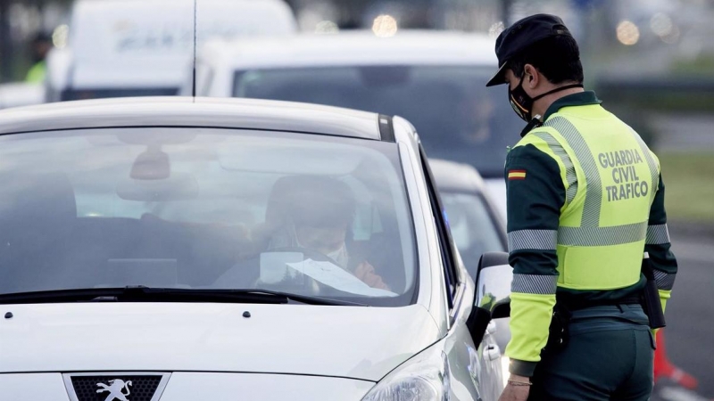 Un agente de la Guardia Civil le pide la documentación al conductor de un vehículo durante un control efectuado en Laredo, Cantabria