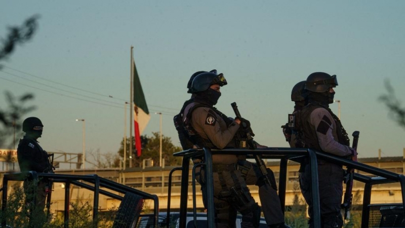 La policía mexicana se para sobre vehículos de patrulla después de que ellos y los funcionarios del Instituto Nacional de Migración cerraron las orillas del Río Grande en el lado mexicano de la frontera en el Parque Ecológico Braulio Fernández el 23 de se