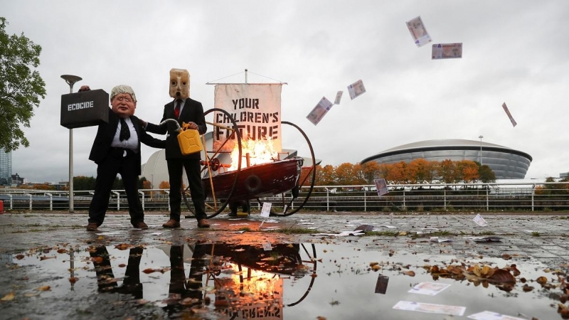 Activistas hacen una performance contra los combustibles fósiles en los aledaños del pabellón donde se celebrará la COP26.