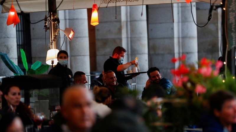 Un camarero atiende una mesa en una de las terrazas de la madrileña Plaza Mayor. REUTERS/Susana Vera