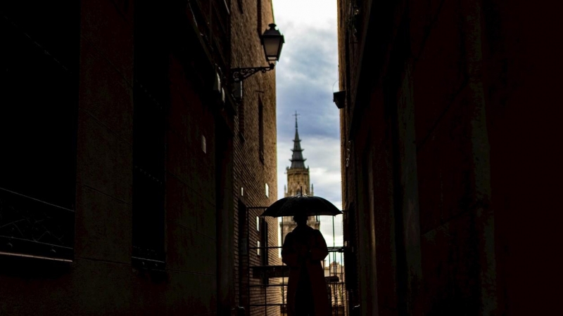 Una mujer pasea por Toledo bajo la lluvia.