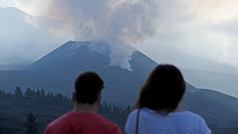 Una pareja observa el volcán y la nube de gases este jueves desde el mirador de Tajuya.