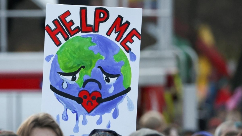 Una pancarta de la Tierra pidiendo ayuda en una manifestación contra la crisis climática en la semana de la Cumbre del Clima de Glasgow (COP26).