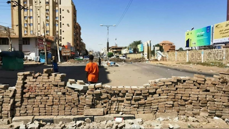 Un joven sudanés apostado frente a las barricadas callejeras construidas durante la noche por manifestantes antigolpistas en la capital, Jartum, tras los llamamientos a la desobediencia civil para protestar por el golpe militar del mes pasado, el 7 de nov