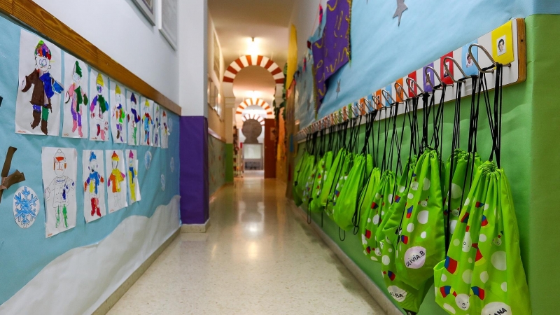 Imagen de archivo de un pasillo con dibujos y mochilas colgadas en una escuela de educación infantil.
