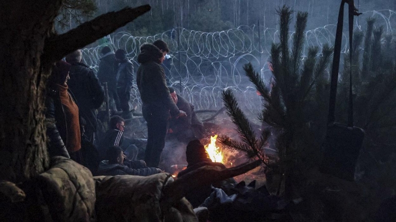 Los migrantes se calientan en su campamento en la frontera entre Bielorrusia y Polonia en la región de Grodno-