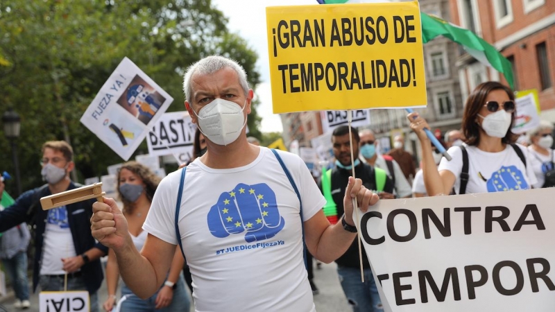 Un hombre sostiene una pancarta donde se lee '¡Gran abuso de temporalidad!', en una manifestación de trabajadores interinos para que sean declarados empleados fijos, a 25 de septiembre de 2021, en Madrid.