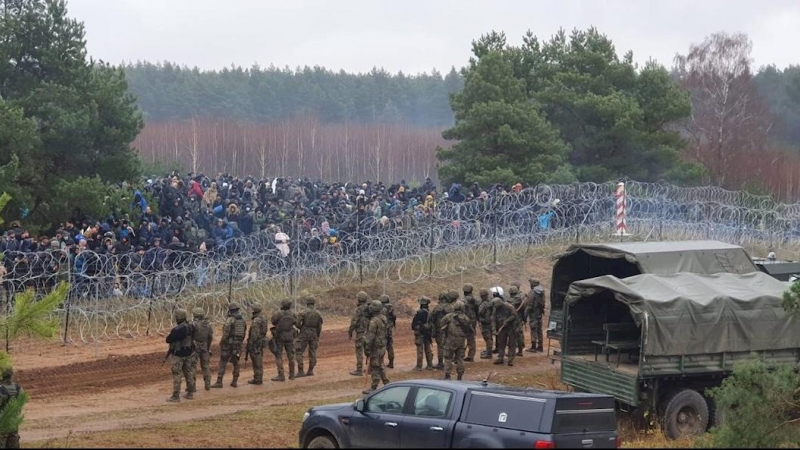 Una fotografía facilitada por la 16º División Mecanizada polaca muestra a los migrantes detrás de la valla fronteriza en Bielorrusia cerca del paso fronterizo polaco-bielorruso en Kuznica, este de Polonia, el 8 de noviembre de 2021 (publicado el 12 de nov