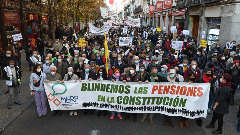 Asistentes con una pancarta donde se puede leer 'Blindemos las pensiones' durante una manifestación que reclama el blindaje de las pensiones en la Constitución, a 13 de noviembre de 2021, en Madrid (España).