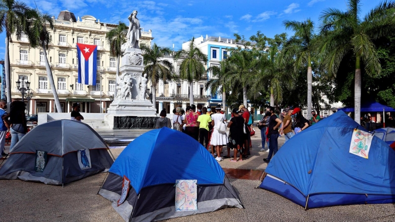 Jóvenes oficialistas instalan hoy carpas durante una sentada con pañuelos rojos en apoyo al Gobierno en el Parque Central de La Habana.