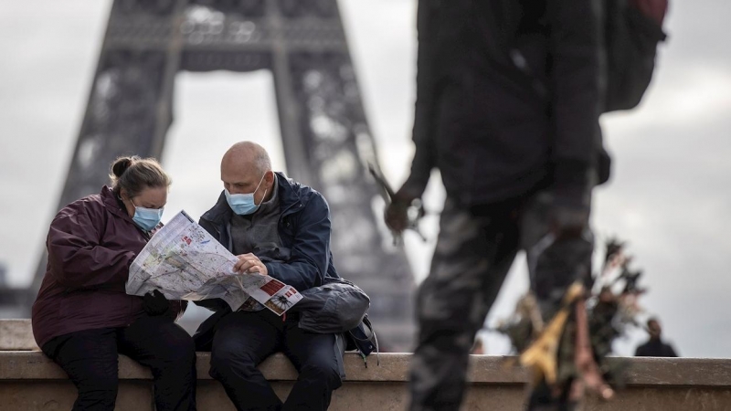 Dos personas despliegan un mapa en París.