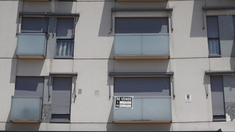 Cartel de se vende en el balcón de un piso de un edificio de Madrid.