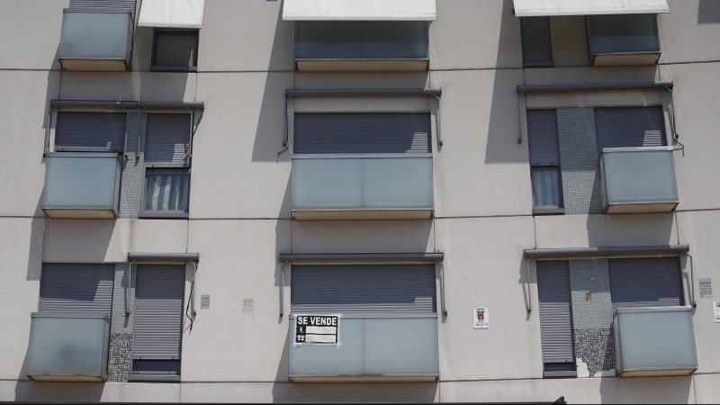 Cartel de se vende en el balcón de un piso de un edificio de Madrid.