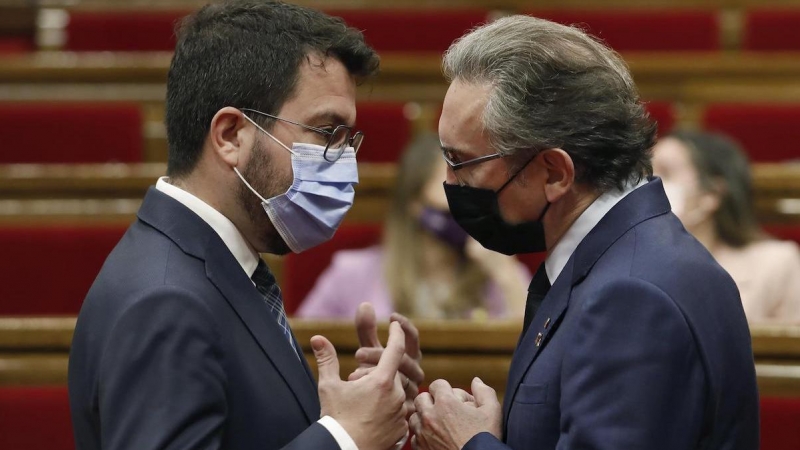 El president, Pere Aragonès, habla con el conseller d'Economia, Jaume Giró, durante la sesión de control en el Parlament.