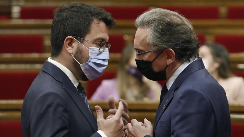 El president, Pere Aragonès, habla con el conseller d'Economia, Jaume Giró, durante la sesión de control en el Parlament.