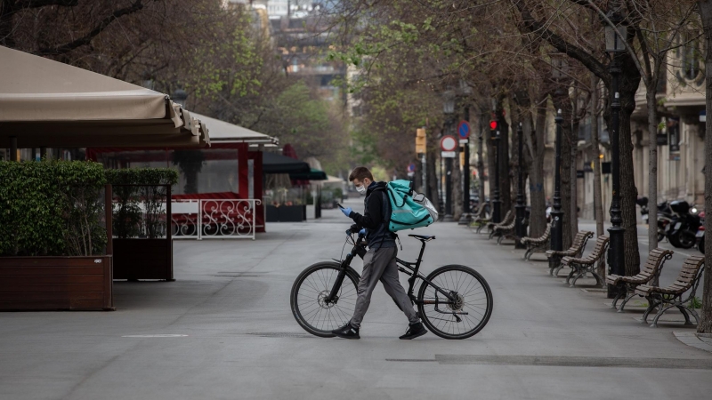 Un trabajador de Deliveroo en bicicleta por una calle de Barcelona.