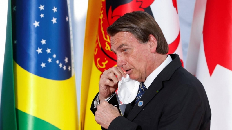 El presidente de Brasil, Jail Bolsonaro, se quita la mascarilla a su llegada a la cumbre del G20 en Roma el 30 de octubre de 2021.