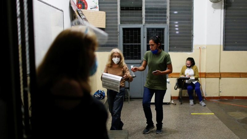 Trabajadores del colegio electoral esperan al cierre de las urnas.