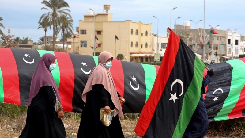 Una mujer libia porta una bandera nacional en la capital, Trípoli, el 25 de febrero de 2021.