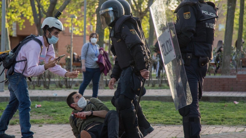 El periodista Guillermo Martínez, en el suelo junto a dos policías antidisturbios, el 7 de abril de 2021, día del mitin de Vox en Vallecas