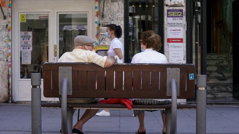 Una pareja de ancianos con mascarilla sentada en un banco, el 27 de julio de 2021, en Madrid, (España).