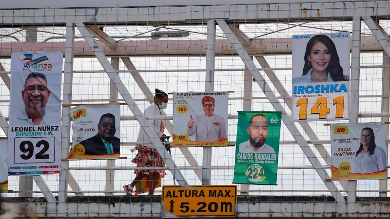 23/11/2021 Una mujer camina por un puente peatonal donde han instalado propaganda política en Tegucigalpa (Honduras)