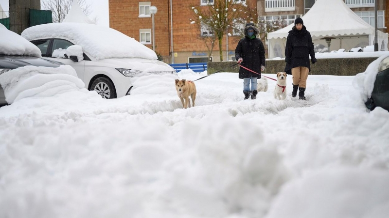 Dos personas caminan este domingo sobre la nieve acumulada en la localidad cántabra de Reinosa.