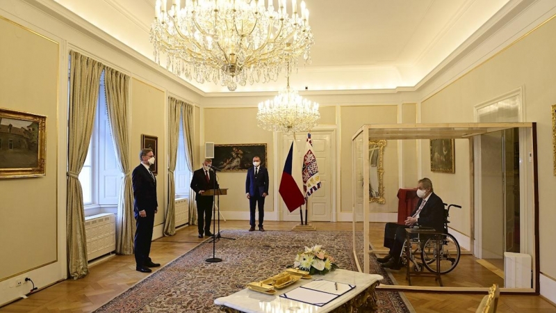El presidente checo Milos Zeman, que ha dado positivo en covid, es conducido en una silla de ruedas a una jaula de plástico desde donde nombrará primer ministro checo a Petr Fiala, líder de la coalición conservadora Spolu (Juntos).