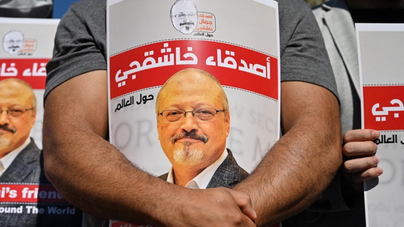 Amigos del periodista saudita asesinado Jamal Khashoggi sostienen carteles con su foto.