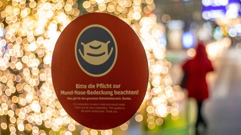 Un cartel que indica el uso de máscarillas se coloca en las puertas de una estación principal de trenes en Berlín.