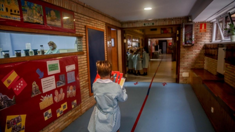 Un niño camina con libros por el hall del colegio Virgen de Europa durante el primer día de clase del curso 2021-22, a 6 de septiembre de 2021, en Boadilla del Monte, Madrid.