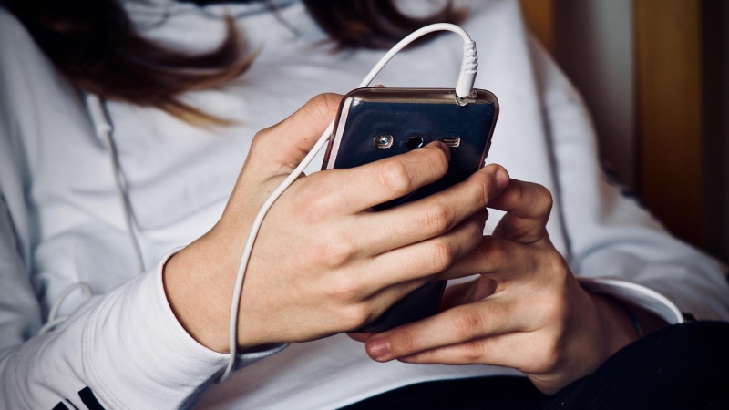 Una joven utiliza su teléfono móvil.