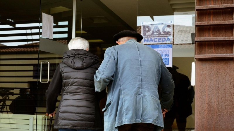 15/12/21. Una pareja de personas mayores se ayuda mutuamente en la puerta de un centro de salud de Ourense, a 25 de octubre de 2021.