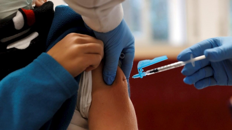 Personal sanitario vacuna a un menor de 12 años en València.