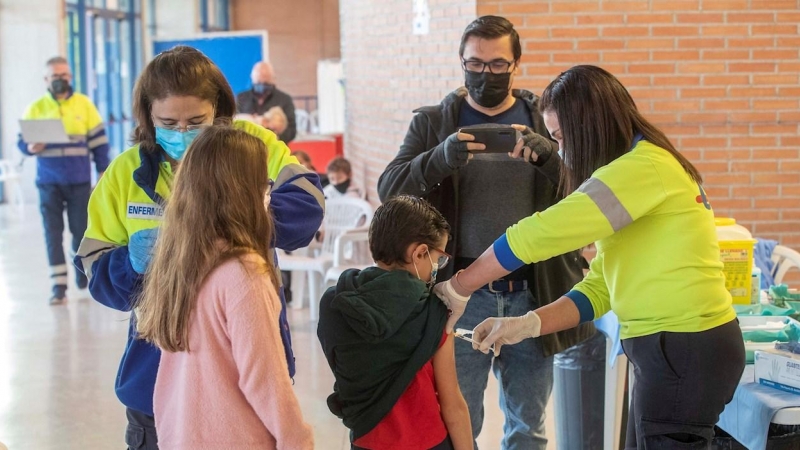 Una enfermera de Servicio Murciano de Salud administra la vacuna de la covid a un niño acompañado, este miércoles en el Palacio de los Deportes de Murcia, donde han comenzado a vacunar a los niños menores de 12 años.