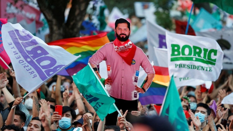 Asistentes al acto de fin de campaña de Boric ondeando banderas.