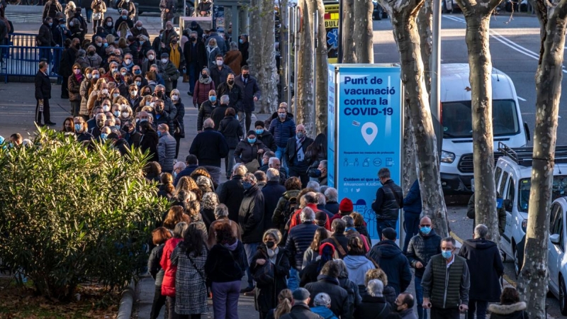 Personas hacen cola frente al centro de vacunación instalado en Barcelona antes de recibir la dosis de refuerzo de la vacuna contra el coronavirus, a 15 de diciembre de 2021.