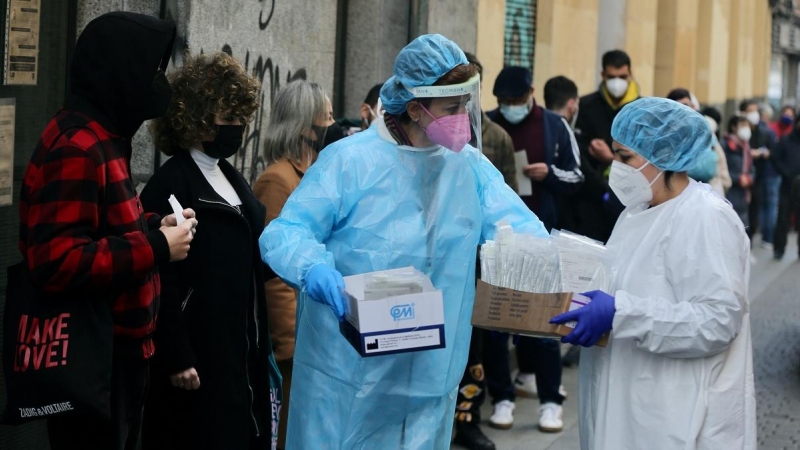 Dos sanitarias recogen test de covid-19 de las personas que hacen cola en el Centro de Salud Universidad.