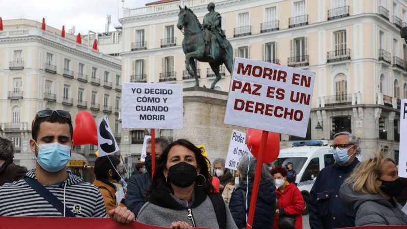 Una mujer con un cartel en el que se lee: `Morir en paz es un derecho´ durante una concentración de Derecho a Morir Dignamente en la Puerta del Sol, en Madrid, a 18 de marzo de 2021.