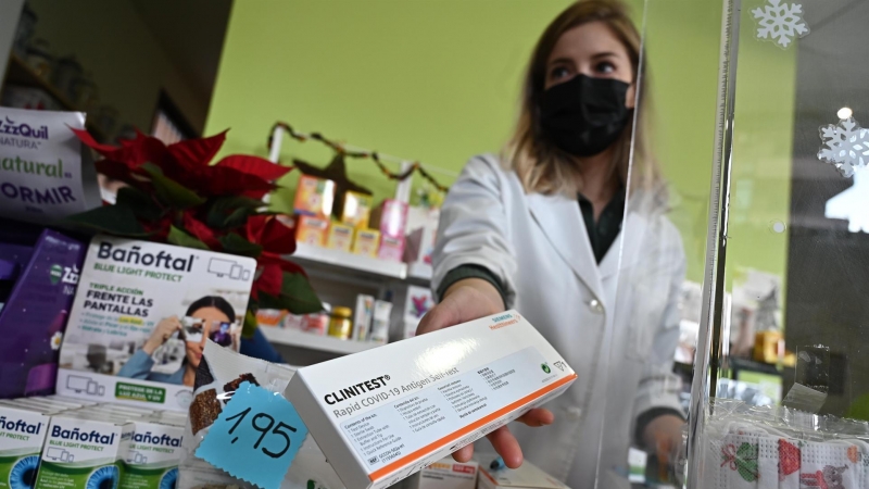 Una farmaceútica muestra el último test de antígenos que tiene disponible a la venta en su farmacia de Madrid este martes 21 de diciembre de 2021.