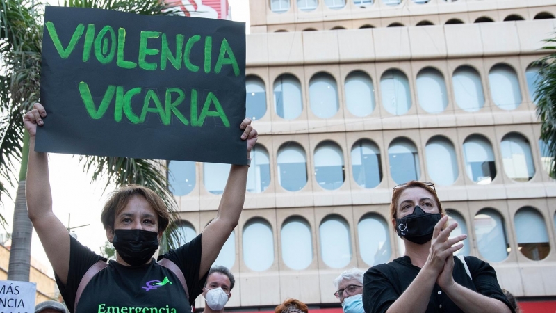 Un mujer con un cartel en el que se lee: Violencia vicaria, participa en una concentración feminista en Tenerife.