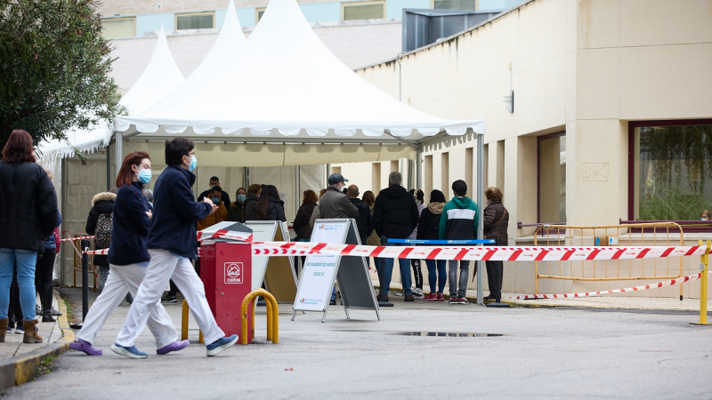 Varias personas esperan la cola en una carpa del Hospital Universitario Gregorio Marañón instalada para hacerse PCR, a 24 de diciembre de 2021, en Madrid.