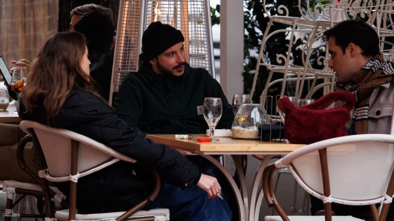 Tres amigos toman el aperitivo en la calle de Ponzano para celebrar la llegada de la Nochebuena, a 24 de diciembre de 2021, en Madrid.