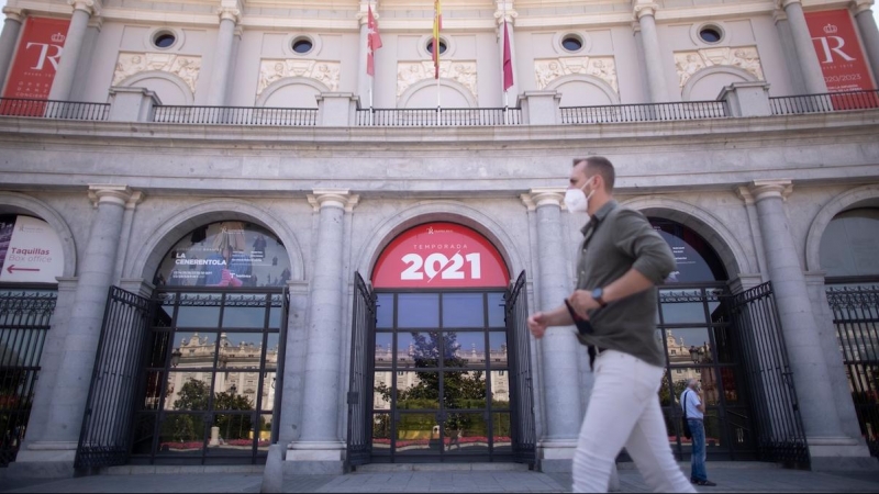 Un hombre con mascarilla frente al Teatro Real, durante el último día en el que es obligatorio el uso de la mascarilla en exteriores, a 25 de junio de 2021, en Madrid.