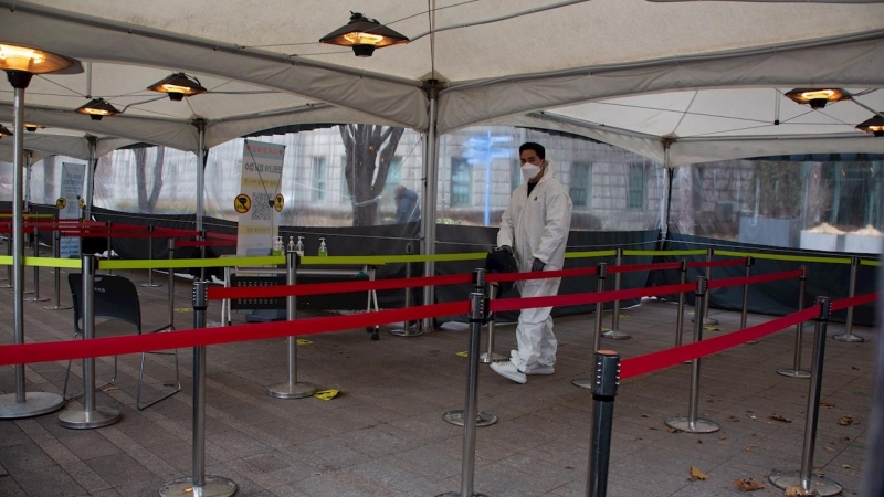 Un trabajador surcoreano rocía desinfectante como precaución contra la propagación del coronavirus en una estación de pruebas COVID-19 improvisada en Seúl, Corea del Sur, el 27 de diciembre de 2021.