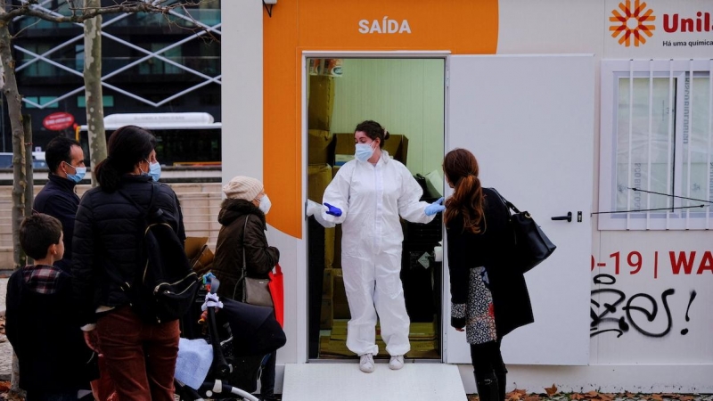Un trabajador de la salud habla con las personas mientras esperan para hacerse las pruebas de la covid en Lisboa, Portugal, el 23 de diciembre de 2021.